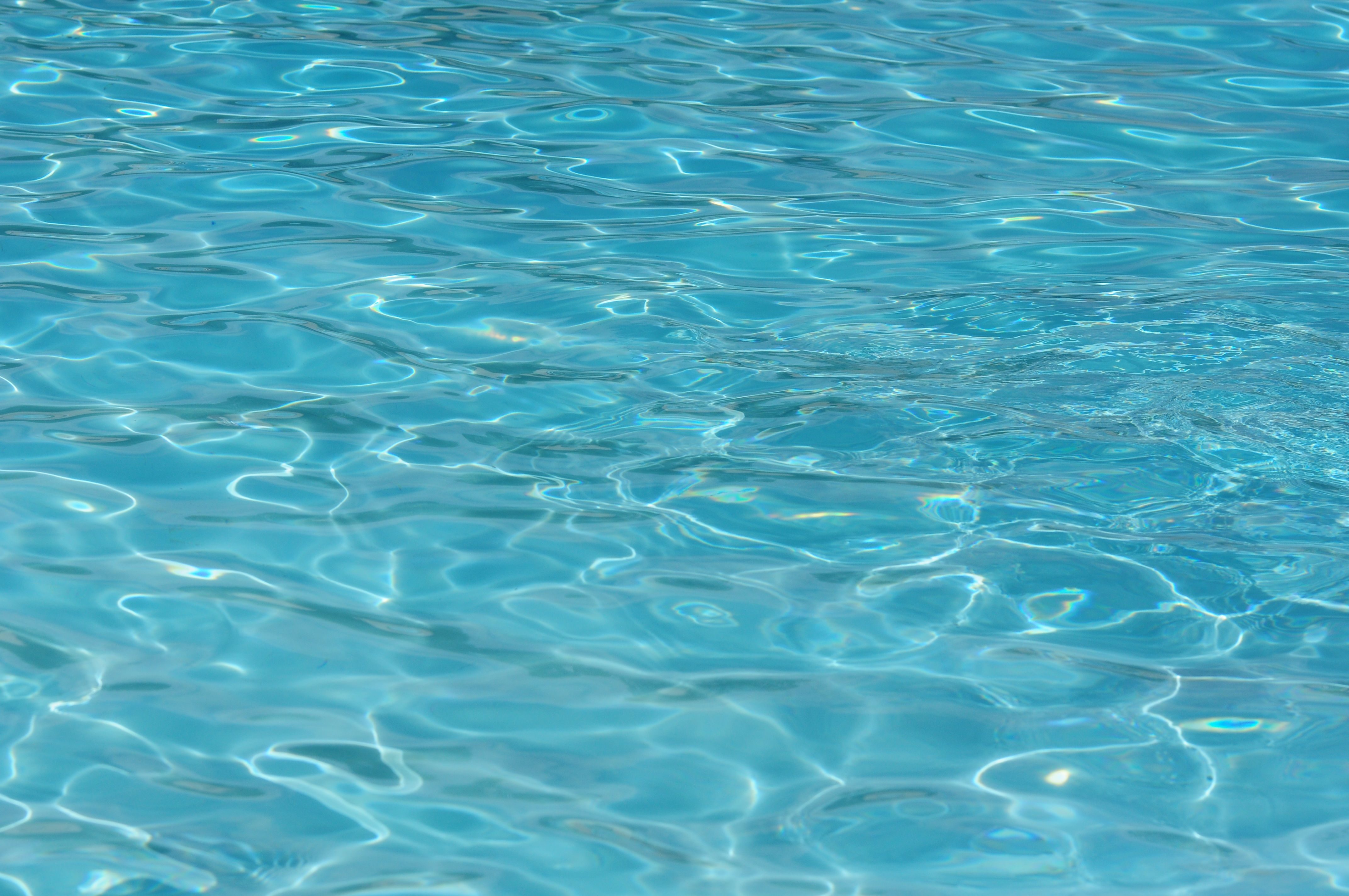 Zacht bewegend zwembadwater met blauwe tegels