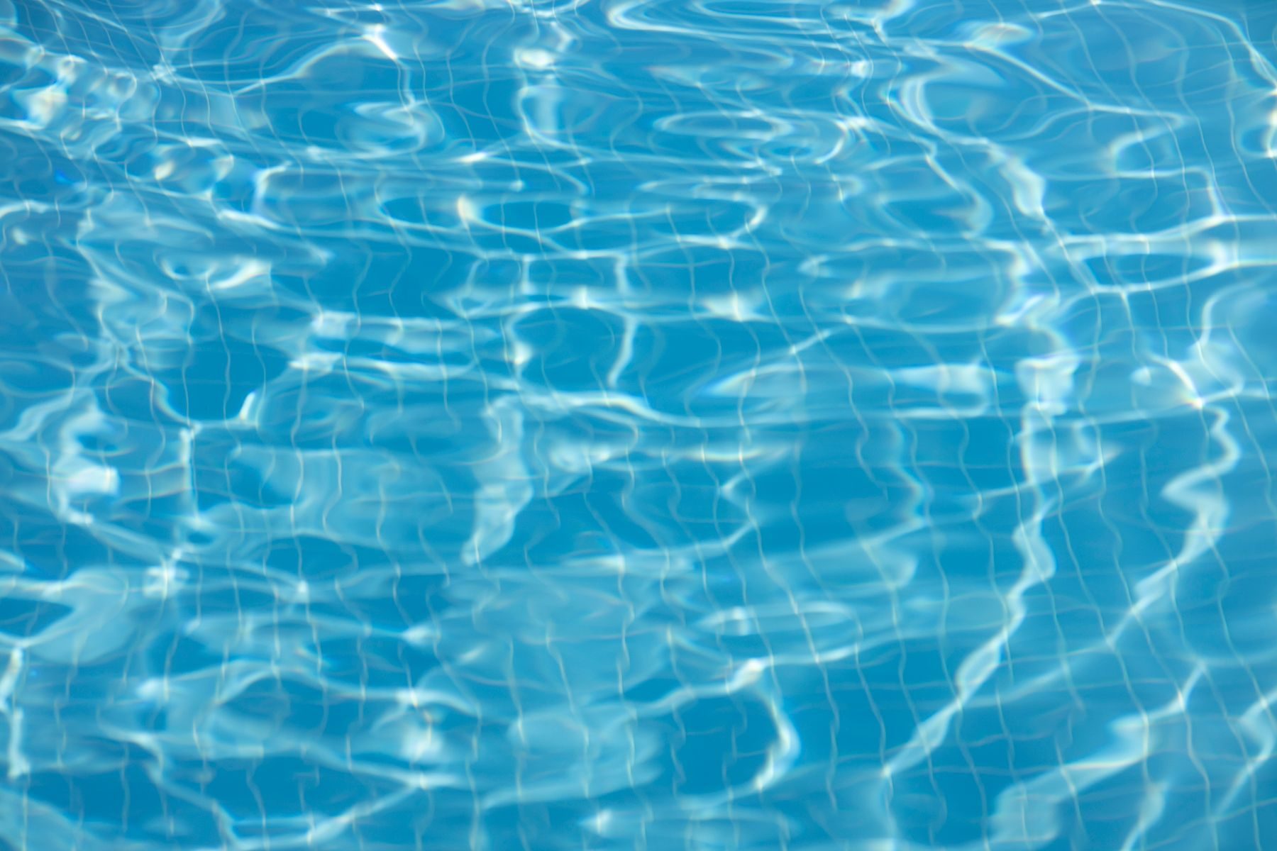 Zacht bewegend zwembadwater met blauwe tegels