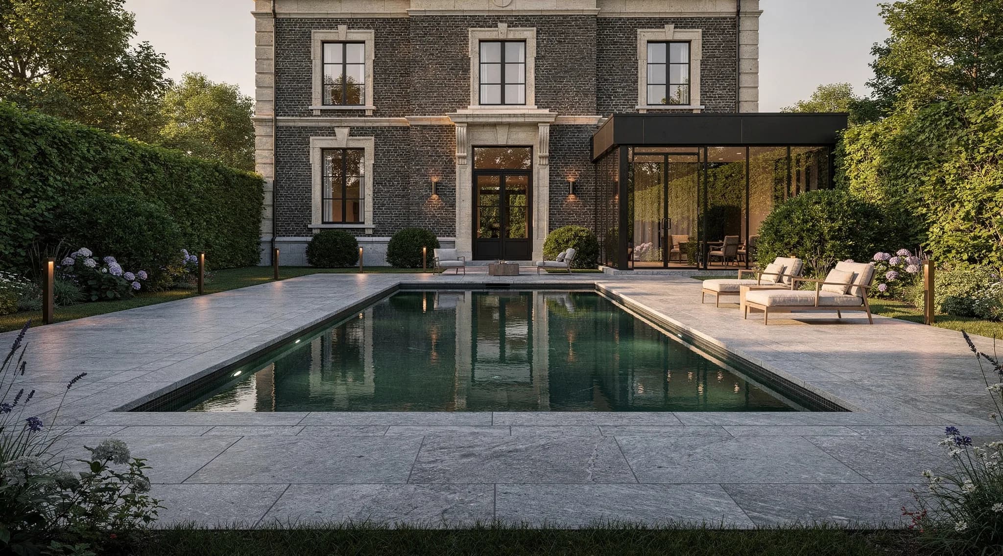 Conceptbeeld van een privaat zwembad in de tuin van een Belgische villa bij avondlicht, met natuursteen en strak geschoren hagen